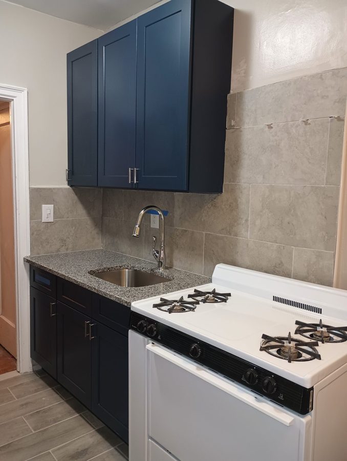 Finished kitchen renovation with navy cabinets and granite countertops